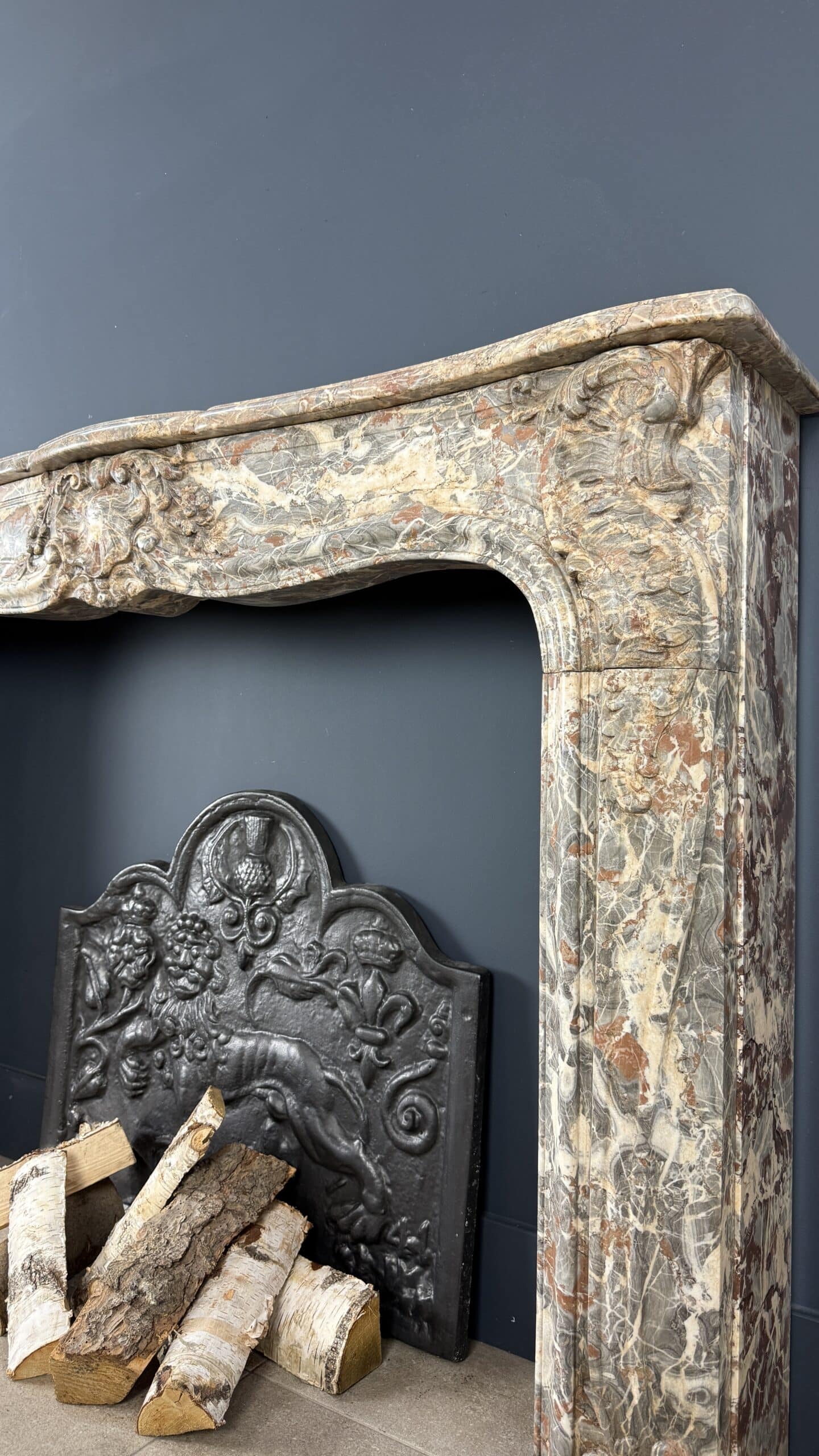 Deze indrukwekkende antieke schouw, afkomstig uit België en vervaardigd rond 1800, is een waar meesterwerk in natuursteen.
