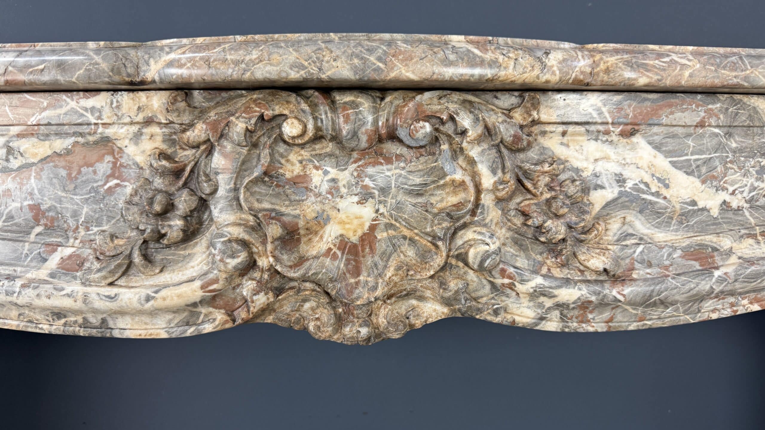 Deze indrukwekkende antieke schouw, afkomstig uit België en vervaardigd rond 1800, is een waar meesterwerk in natuursteen.