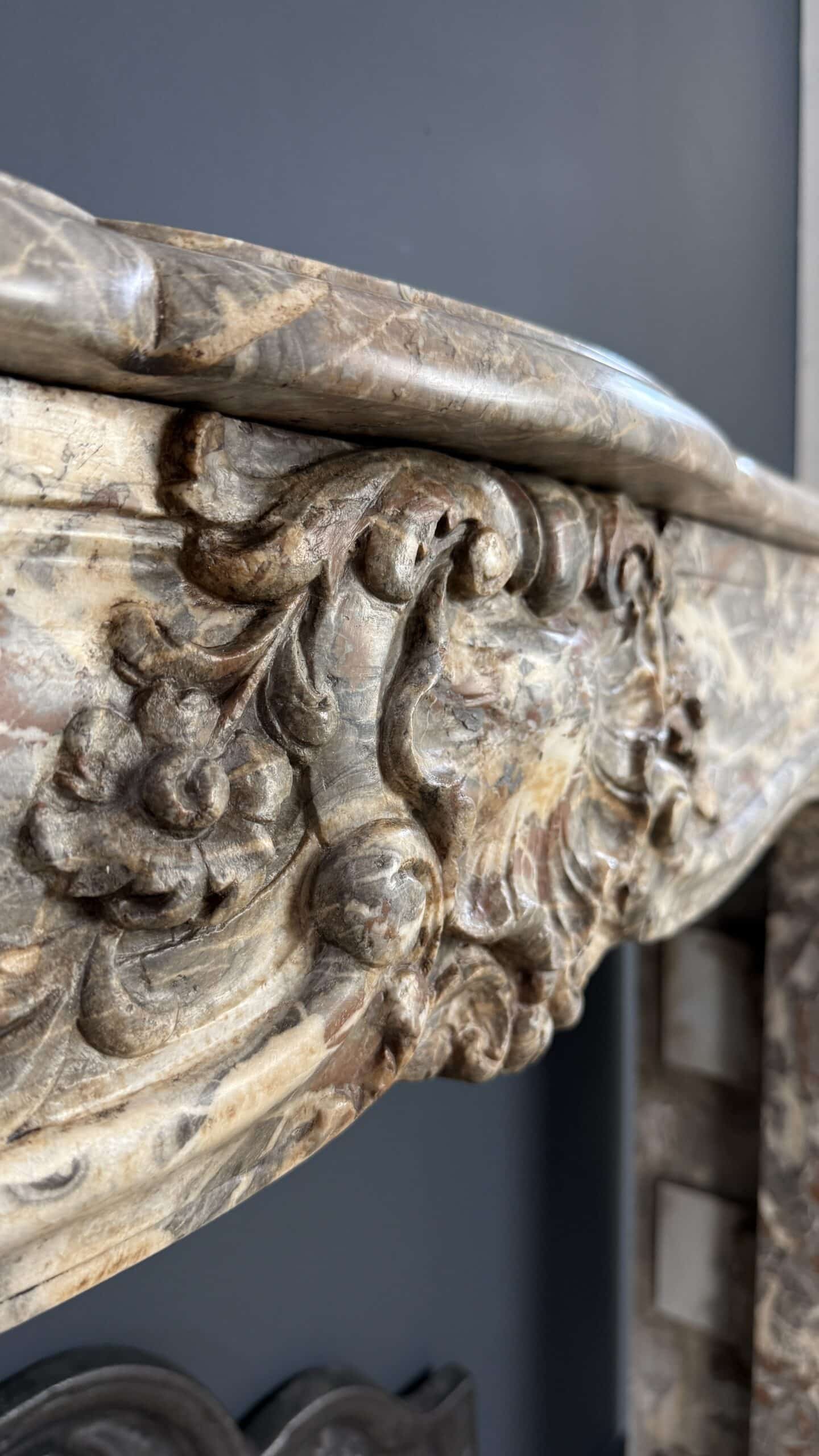 Deze indrukwekkende antieke schouw, afkomstig uit België en vervaardigd rond 1800, is een waar meesterwerk in natuursteen.